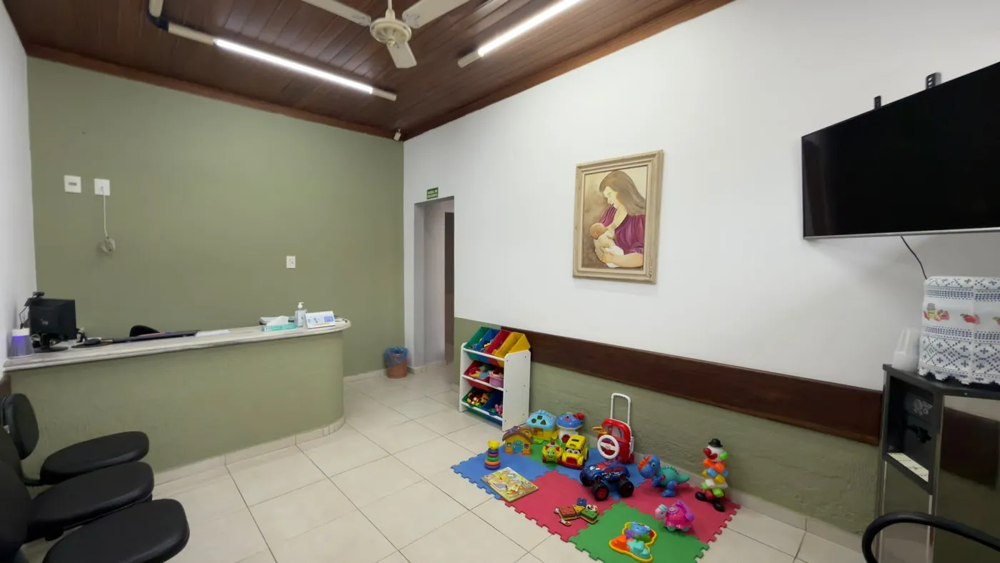 Sala de espera do consultório, com tapete, brinquedos e cadeiras
